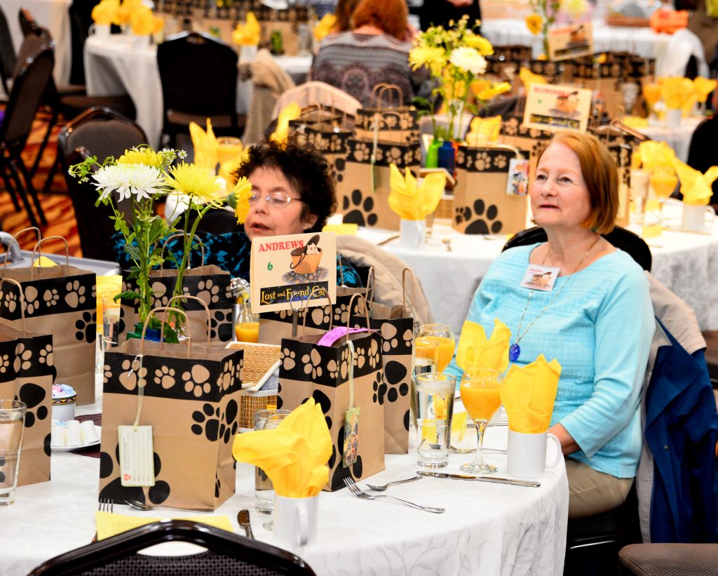 Donors listening intently at Touched By An Animal's 2018 Books and Baskets Benefit Brunch.